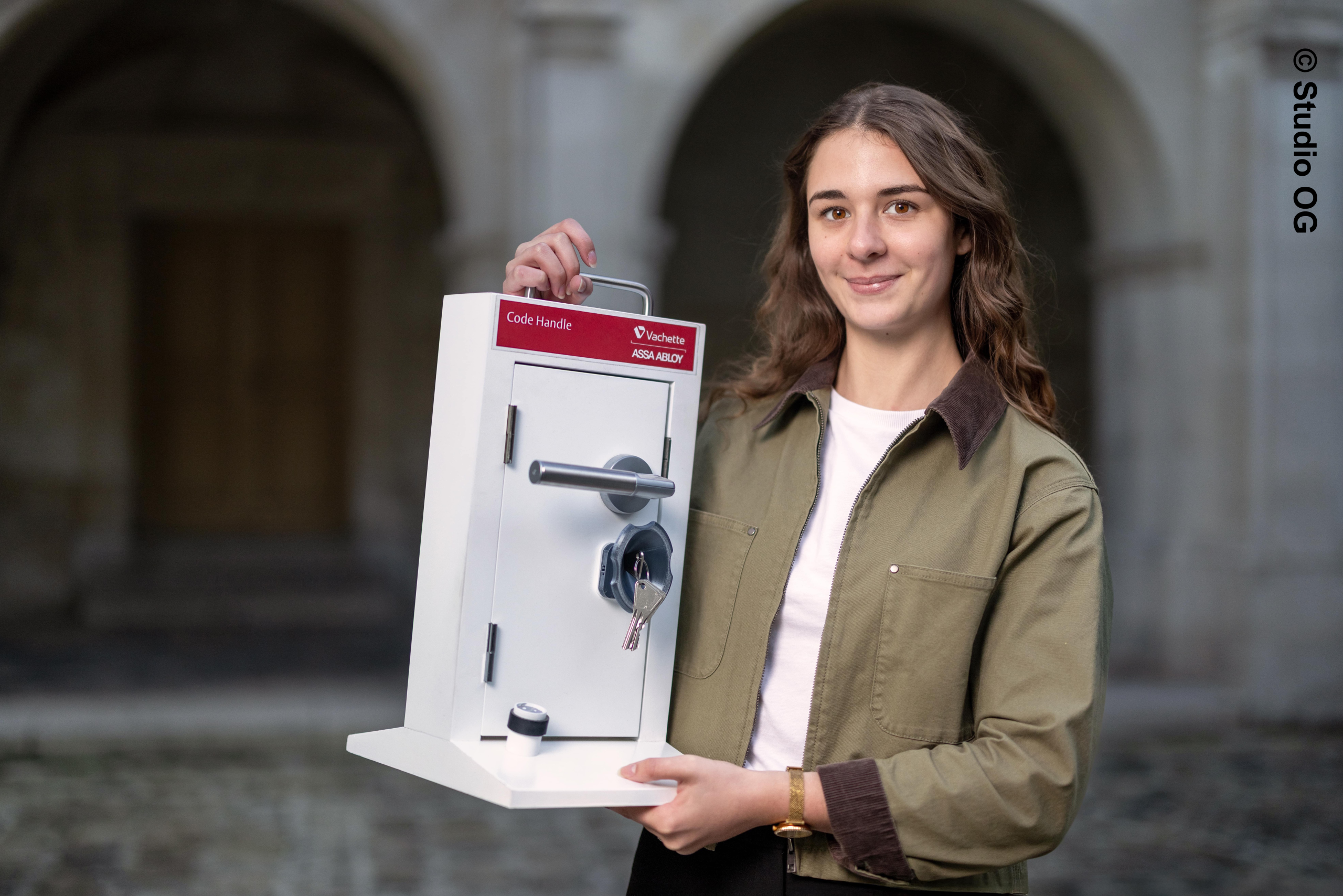 Photo d'Anaïs Remen qui tient son projet de serrure inclusive dans les mains